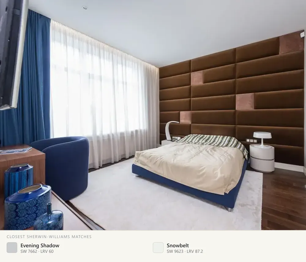 White bedroom with a padded wall