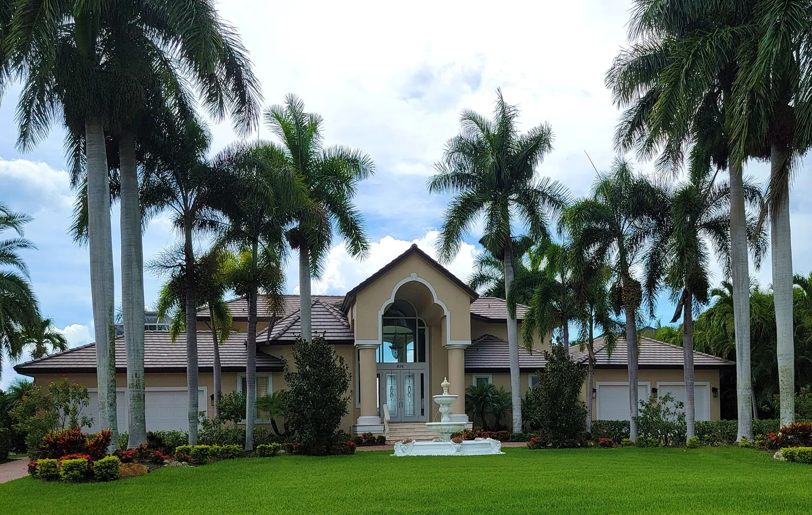 Grand Florida estate behind a row of royal palms