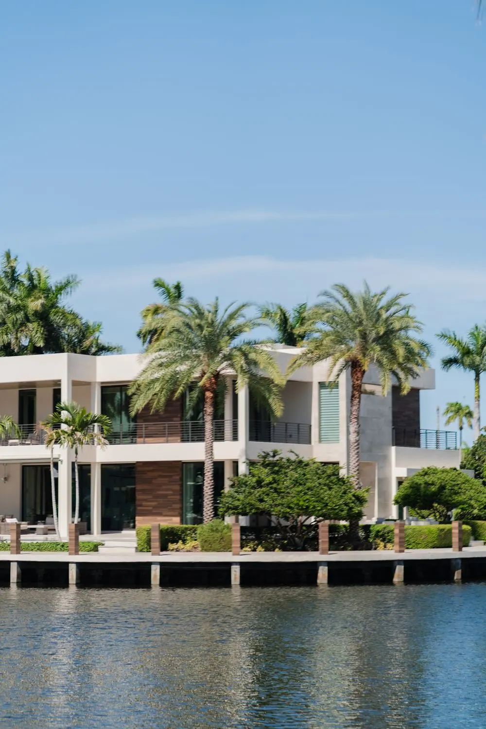 Modern waterfront villa surrounded by palms