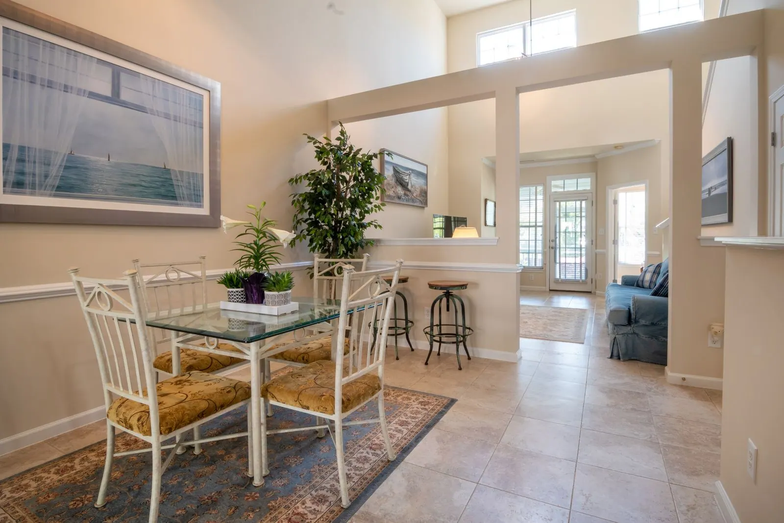 Florida dining area with beige walls, white chair rail and tile floors