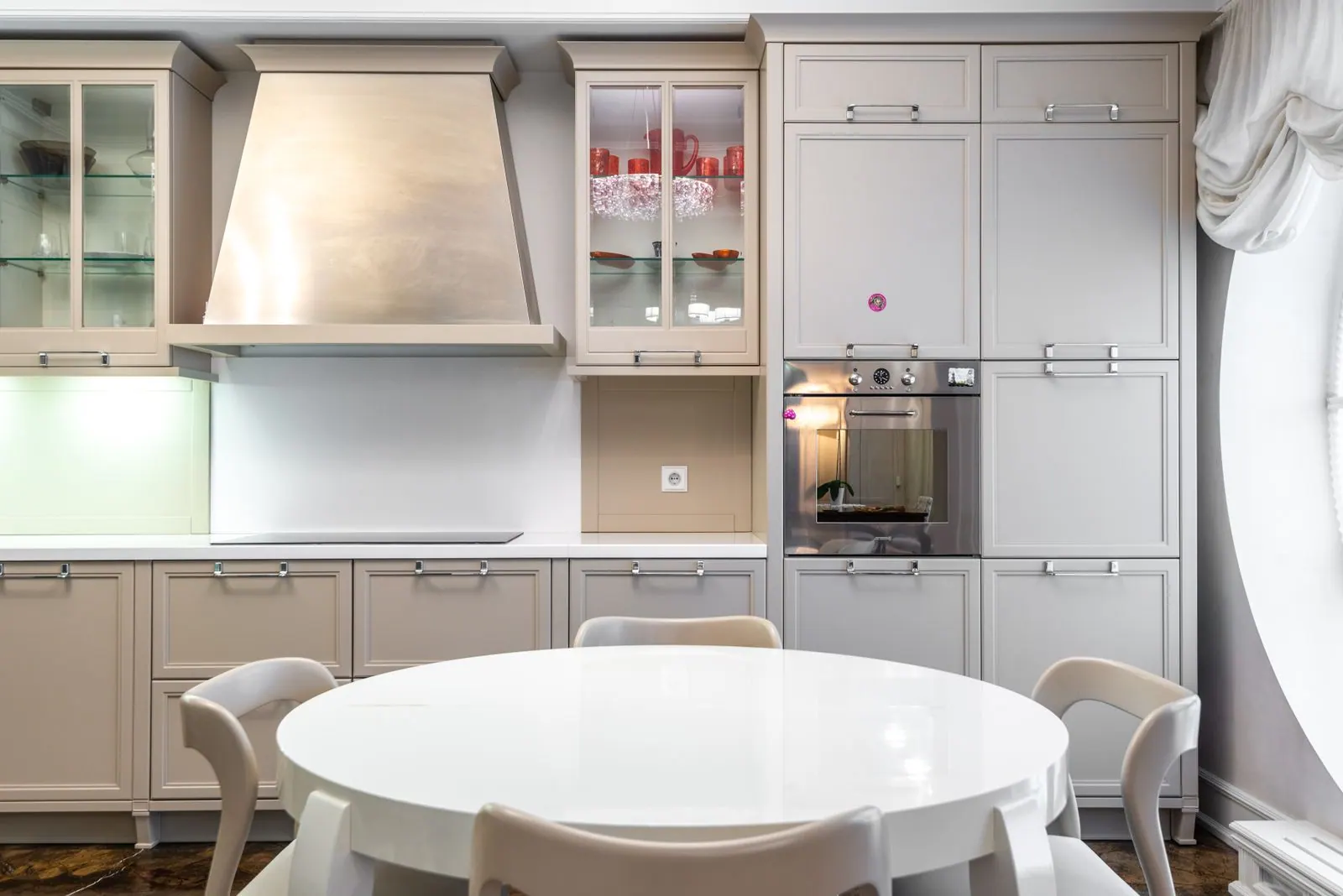 Kitchen with greige painted cabinetry and a round dining table